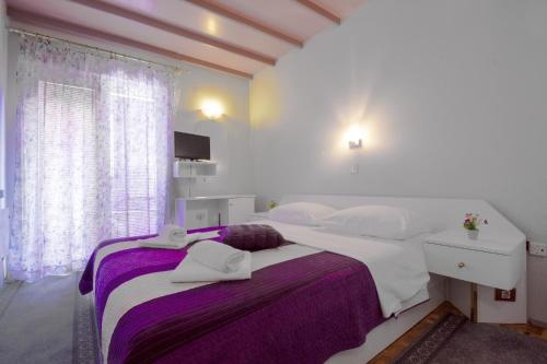 シベニクにあるRooms by the sea Brodarica, Sibenik - 478のタオルが敷かれた大きなベッドのある寝室