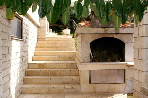 a stone fireplace with stairs in front of a house at Studio Zavalatica 547a in Zavalatica