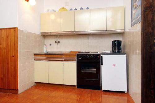 uma cozinha com um fogão a preto e branco e frigorífico em Apartments by the sea Zavalatica, Korcula - 546 em Zavalatica