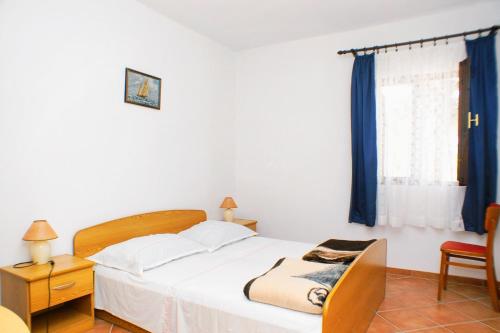 1 dormitorio con 1 cama, 1 silla y 1 ventana en Apartments by the sea Mandre, Pag - 523, en Kolan