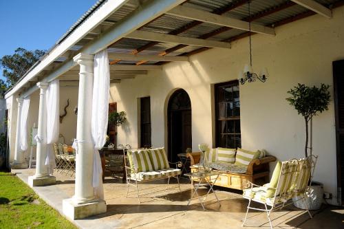 an outdoor patio with chairs and a pergola at Hawksmoor House in Stellenbosch