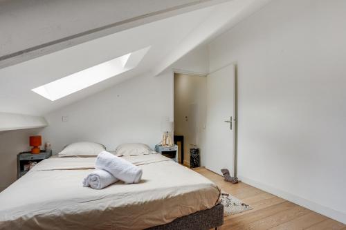 ein Schlafzimmer mit einem Bett mit Handtüchern darauf in der Unterkunft Le Marquis- Versailles in Versailles