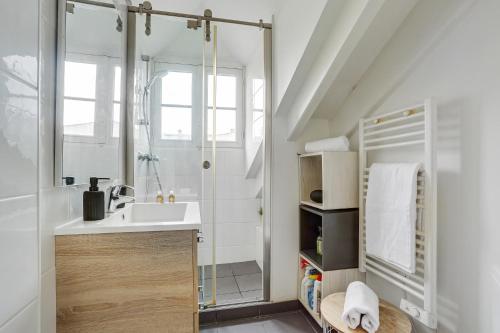 ein Bad mit einem Waschbecken und einer Dusche in der Unterkunft Le Marquis- Versailles in Versailles
