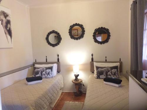 2 Betten in einem Zimmer mit Spiegeln an der Wand in der Unterkunft African Elephant's Den in Klerksdorp