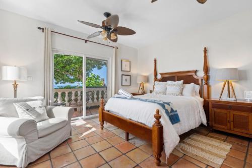 a bedroom with a bed and a chair and a window at Tres Sirenas Beach Inn in Rincon