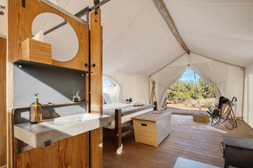 uma casa de banho numa tenda com um lavatório e um espelho em Under Canvas Grand Canyon em Valle