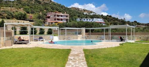 a swimming pool in the middle of a yard at Belvedere Luxury Apartments & Spa in Plakias