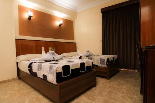two beds in a hotel room withskirts at New Saint Catherine Hotel in Luxor