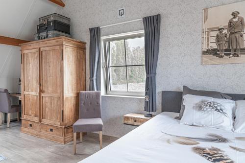 - une chambre avec un lit, une fenêtre et une chaise dans l'établissement B&B meetje verre, à Assenede