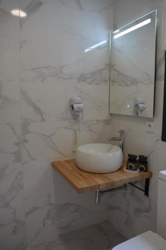 a bathroom with a sink and a mirror at Cabañas Compostela - Cabaña Pedroso con bañera de hidromasaje in Santiago de Compostela