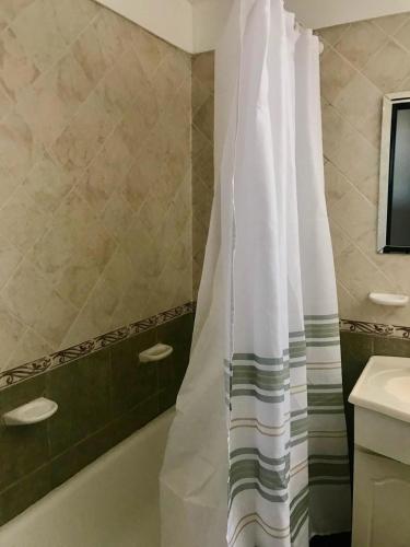a bathroom with a shower curtain and a sink at Duplex Gral .Viamonte 27- Tandil in Tandil