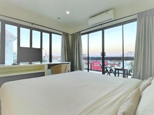 um quarto de hotel com uma cama e uma grande janela em The Empire Nimman em Chiang Mai