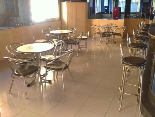 a row of tables and chairs in a restaurant at Hostal Centro Ejido in El Ejido