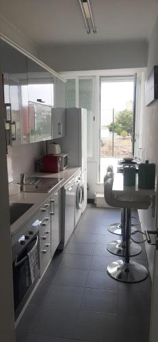 a kitchen with a sink and a table in it at Minimalist Apartment Located near Belém in Lisbon