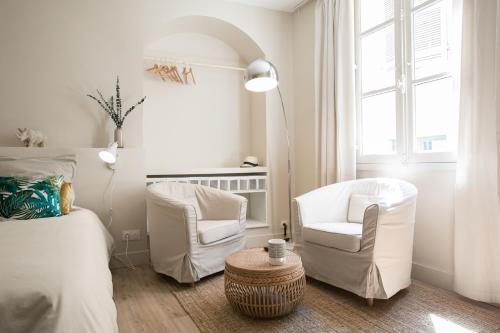 a bedroom with two chairs and a bed and a table at L'Otentik-Clim-Centre Historique- in Périgueux