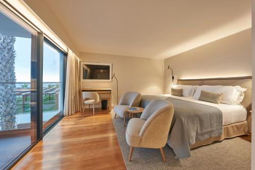 a hotel room with a bed and a large window at La Villa at The Cliff Bay - PortoBay in Funchal