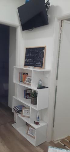 a white book shelf with a chalkboard on a wall at Minimalist Apartment Located near Belém in Lisbon