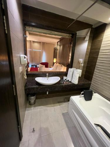 a bathroom with a sink and a large mirror at Lahore Continental Hotel in Lahore