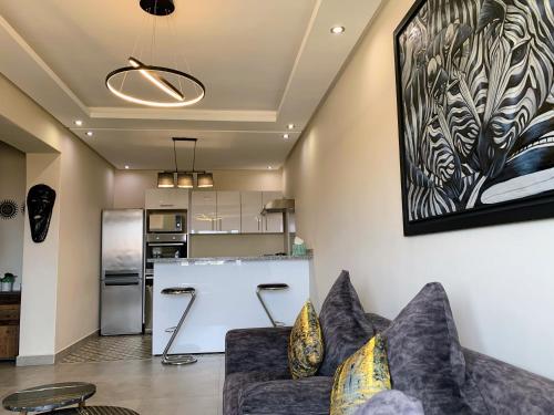 Il comprend un salon avec un canapé et une cuisine. dans l'établissement Moderne, lumineux & spacieux avec balcon -Central -Wifi-Smart TV-Clim, à Marrakech