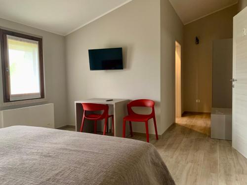 a bedroom with a table and two red chairs at il Giglio B&B in Asola