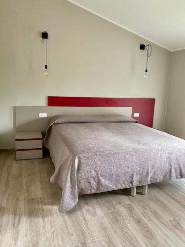a bedroom with a large bed with a red headboard at il Giglio B&B in Asola