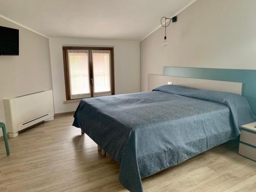 ein Schlafzimmer mit einem blauen Bett und einem TV in der Unterkunft il Giglio B&B in Asola