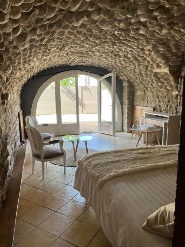 Habitación con cama, mesa y sillas. en GITE DE LA CAPPELLA - CHAMBRE D'HÔTES A VOLTA en Aubenas