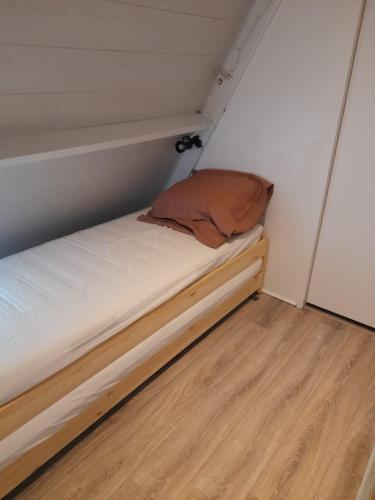 a small bed in a small room with a wooden floor at Cosy Chalet Durbuy in Durbuy