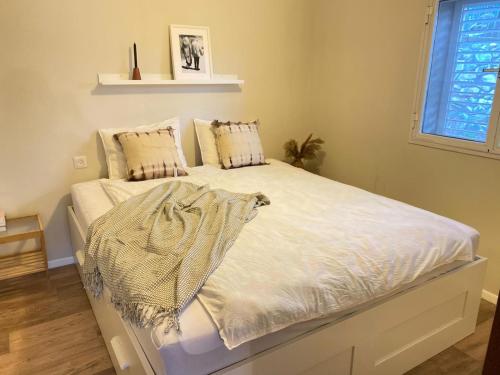 a bed with white sheets and pillows in a bedroom at מול האגם in Ma'alot Tarshiha