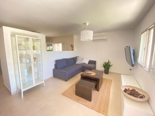 a living room with a blue couch and a table at מול האגם in Ma'alot Tarshiha