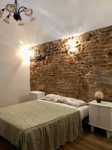 um quarto com uma cama e uma parede de tijolos em La Taverna del Ricetto em Candelo