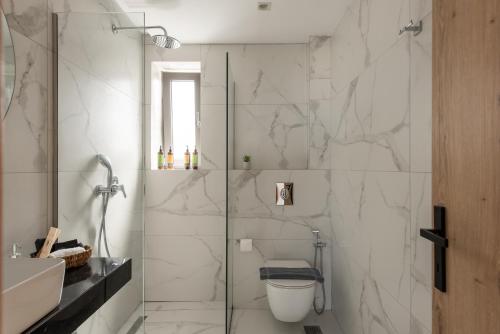 a bathroom with a shower and a toilet and a sink at Mystic Garden Villas in Zakynthos Town