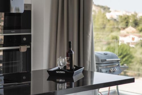 a bottle of wine on a counter next to a window at Mystic Garden Villas in Zakynthos Town