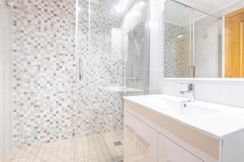 ein weißes Bad mit einem Waschbecken und einer Dusche in der Unterkunft Gemelos 22 Resort Apartment 2-15-B Levante Beach in Benidorm
