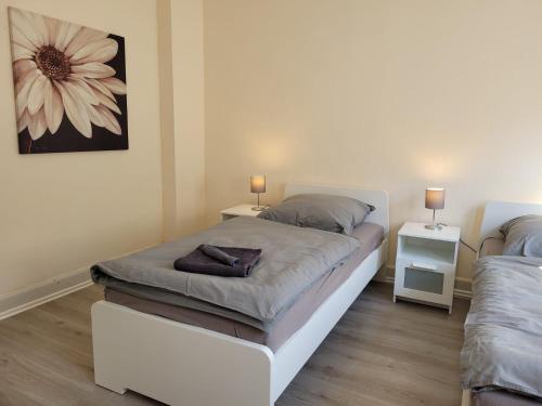a bedroom with two beds and a flower painting on the wall at Große Monteurwohnung oder Fewo bei Nina in Bad Grund