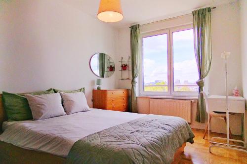 um quarto com uma cama e uma grande janela em Fountain View Apartment em Zagreb