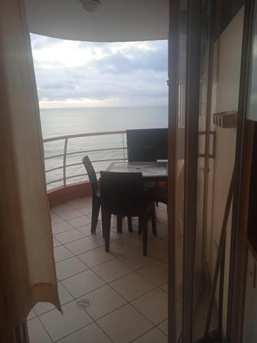 balcón con mesa, sillas y vistas al océano en VACACIONES ARCO IRIS B−201, en Atacames