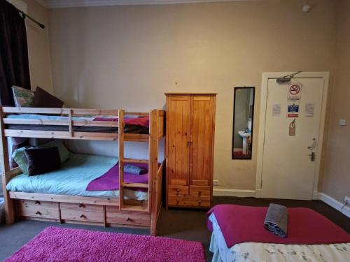 a bedroom with two bunk beds and a mirror at aabAlree Guest House in Dundee