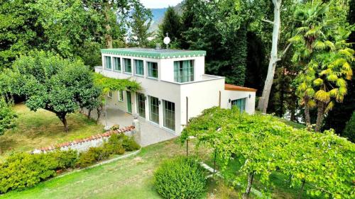 an aerial view of a white house with trees at The Greenhouse Luxury Villa on Lake Como in Como