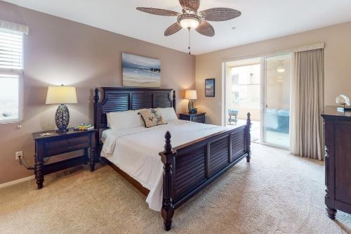 a bedroom with a large bed and a ceiling fan at Ocean Pointe Lagoon #107 in Carlsbad
