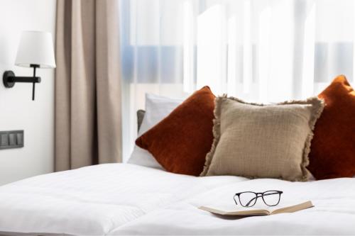 a pair of glasses sitting on top of a bed at H11 Aparthotel in Kraków