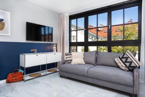 a living room with a couch and a large window at H11 Aparthotel in Kraków