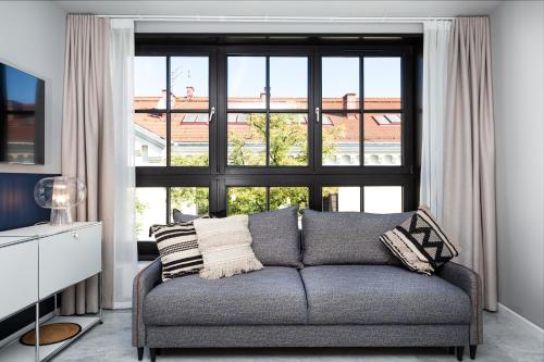 a living room with a couch and a large window at H11 Aparthotel in Kraków