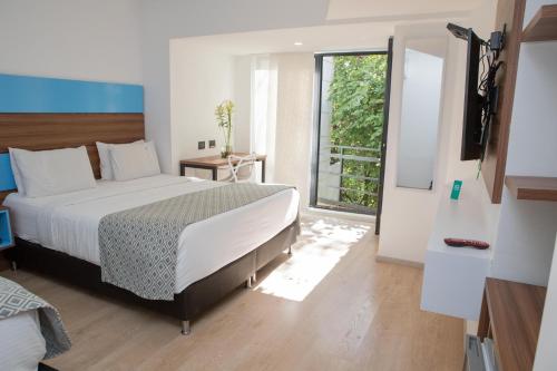 a bedroom with a large bed and a window at Foresta Hotel in Medellín