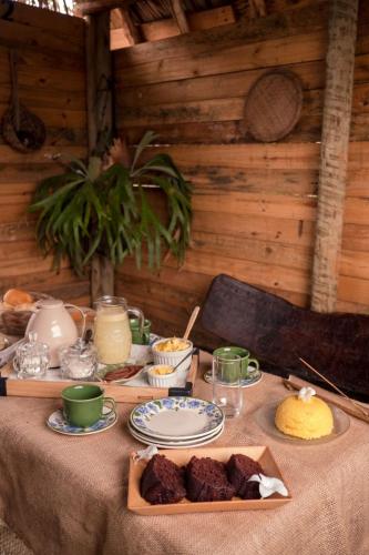 a table with plates of food on top of it at Flor da Aldeia Eco Hospedaria in Camaçari