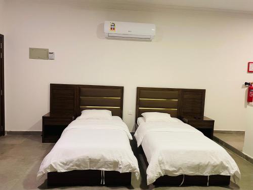 duas camas sentadas uma ao lado da outra num quarto em Al Noor Square em Salalah