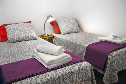 Cette chambre comprend 2 lits jumeaux et une lampe. dans l'établissement Casa Tortilla Sant Antoni, à Barcelone