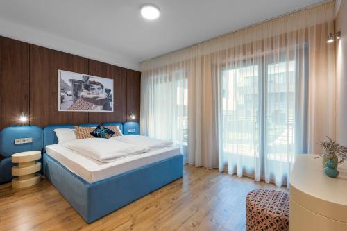 - une chambre avec un lit bleu et une grande fenêtre dans l'établissement The Magazine Rooms, à Budapest