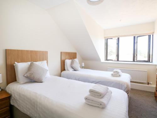 duas camas num quarto com toalhas brancas em Flat 35 - Marine Court em Littlehampton