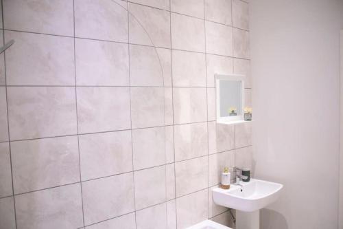 Baño blanco con lavabo y aseo en Fortunae Cosy City Centre Apartments, en Sunderland